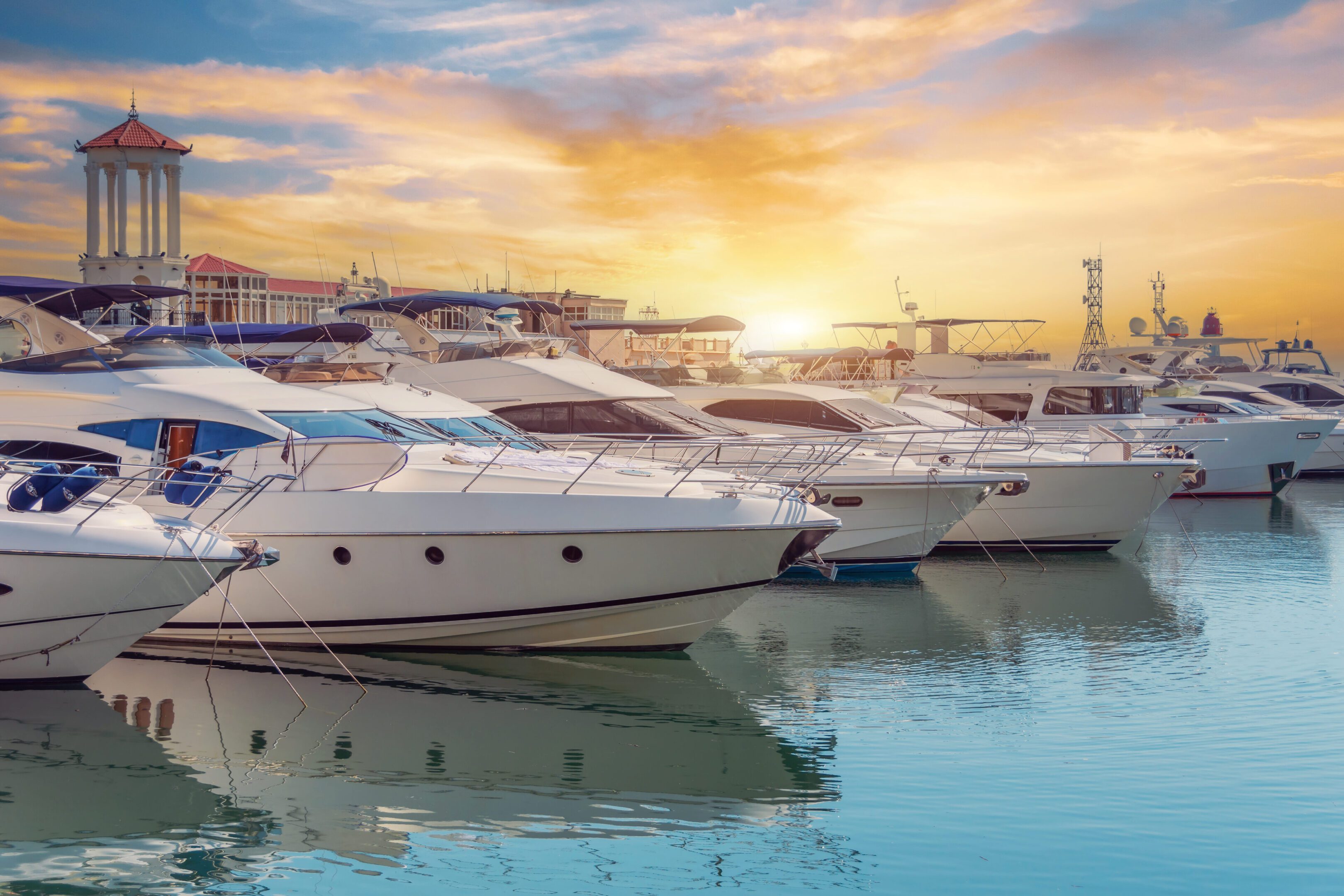 Yachts docked at sunset in marina.
